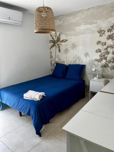 - une chambre dotée d'un lit avec des draps bleus et un mur dans l'établissement Duplex piscine 3 chambres et Clim proche plages, à Villeneuve-lès-Maguelone