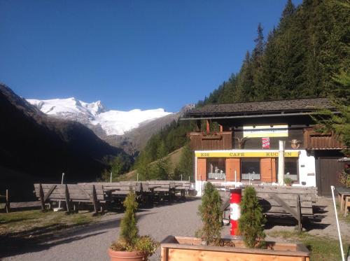 a building with tables and benches in the mountains at Berghaus Außergschlöß in Matrei in Osttirol