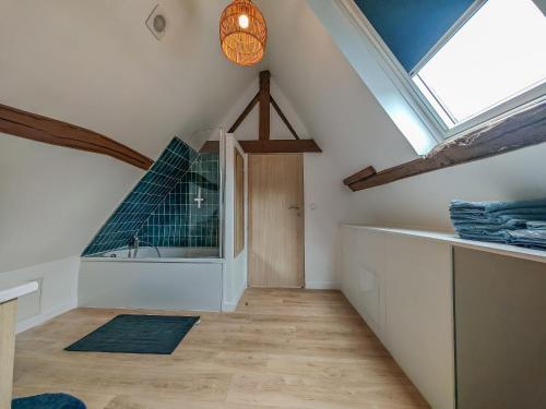 Cette chambre mansardée dispose d'une lucarne et d'une salle de bains. dans l'établissement Belle Maison Honfleuraise 10-14 pers piscine, à Fatouville-Grestain