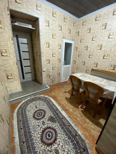 a dining room with a table and a rug at Family hostel Toshkent in Toshkent-Passajir Bekati