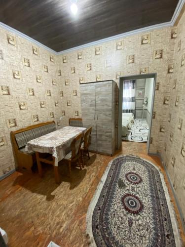 a room with a table and a rug and a wall at Family hostel Toshkent in Toshkent-Passajir Bekati