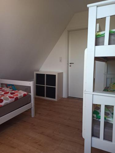 a bedroom with a bunk bed and a ladder at Landblick - idyllische Wohnung an der Nordsee in Simonsberg