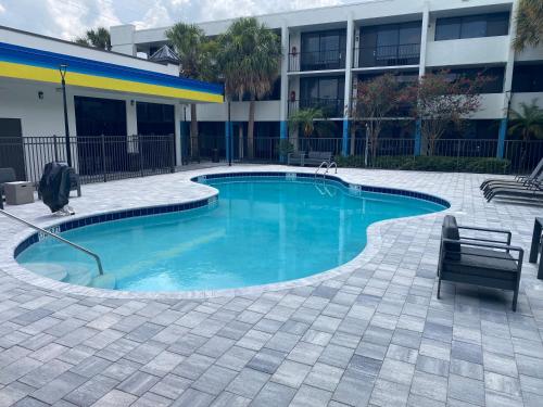 a swimming pool in front of a building at Days Inn & Suites by Wyndham Orlando Airport in Orlando