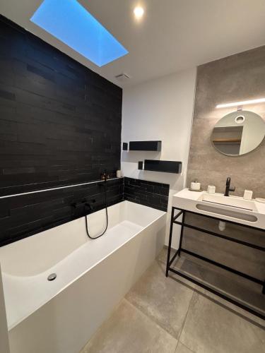 une salle de bain avec une baignoire et un lavabo dans l'établissement Villa d'exception - La Ciot'Art & Détente, Vue Mer et Piscine, à La Ciotat