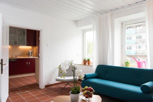 sala de estar con sofá azul y cocina en Zu Hause in Tirol en Kirchbichl