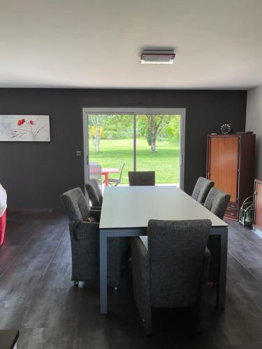 une salle à manger avec une table et des chaises blanches dans l'établissement Maison en rez de jardin, à Pluvigner