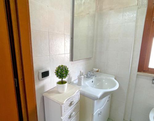 a white bathroom with a sink and a mirror at CAMI MARE BLU Apartment - Steps from the Sea 50mt & Train and Bus Station in Nettuno