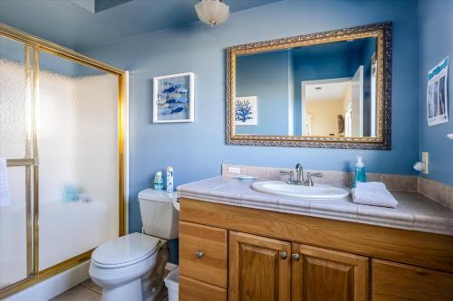 a bathroom with a sink and a toilet and a mirror at A Seaside Escape in San Simeon