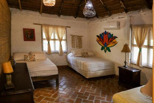 a bedroom with two beds in a room with windows at Cabañas Mannan in Tanchachín