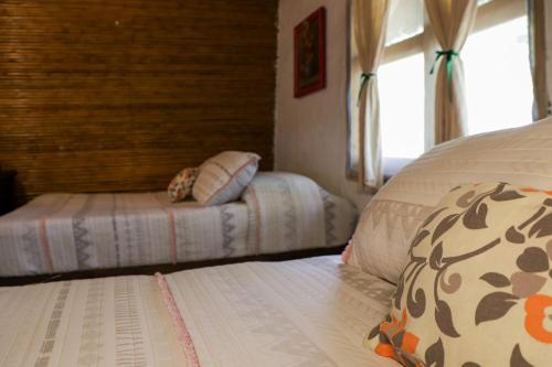 a bedroom with two beds and a window at Cabañas Mannan in Tanchachín