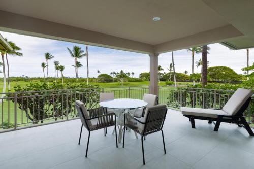 un patio avec une table et des chaises sur un balcon dans l'établissement 3BD Fairways Villa (104A) at Hualalai Resort, à Kukio