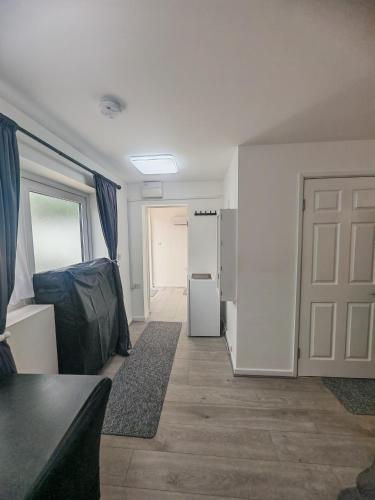 a living room with a door and a refrigerator at Ensuite Double Room with Kitchen in Hayes