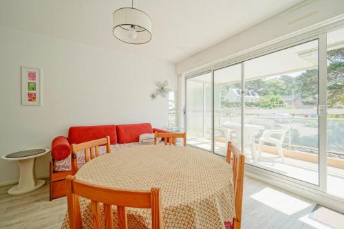 a dining room with a table and a couch at Granit & Vagues - Balcon vue mer, séjour à Trébeurden, front de mer in Trébeurden