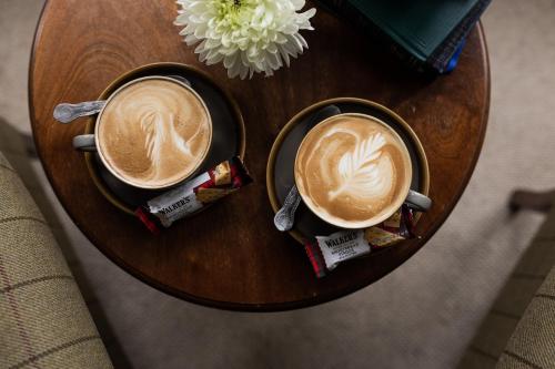 two cups of coffee on a wooden table at Craigellachie Hotel of Speyside in Craigellachie