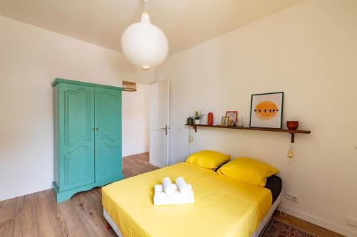 - une chambre avec un lit jaune et une armoire bleue dans l'établissement LX151 Calme confort & style en coeur de ville, à Menton