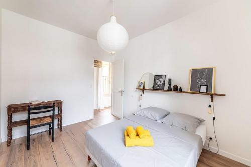 - une chambre avec un lit et 2 oreillers jaunes dans l'établissement LX151 Calme confort & style en coeur de ville, à Menton