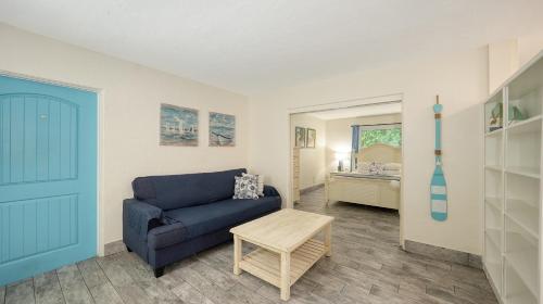 a living room with a blue couch and a bedroom at Siesta Key Palms Resort in Sarasota