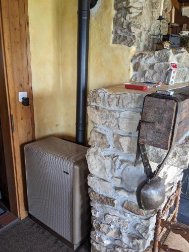 a stone wall with a stove in a room at Chalet Les Bises in Courtelary