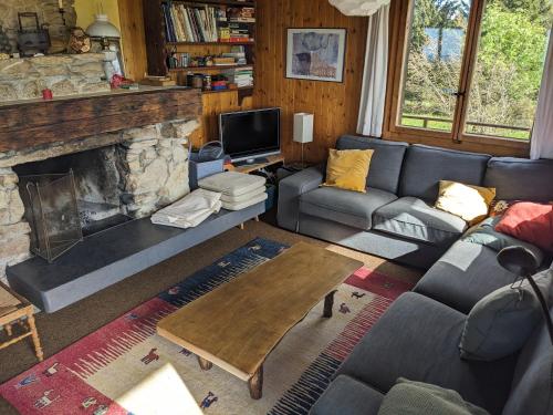 a living room with a couch and a fireplace at Chalet Les Bises in Courtelary