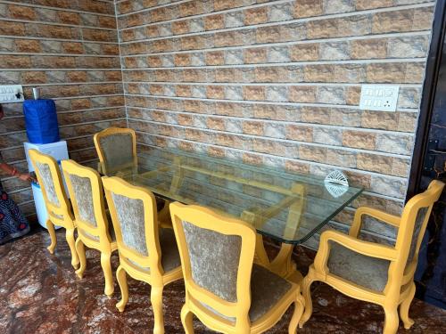 a glass table and chairs sitting next to a brick wall at Popli Paradise Resort in Jaipur