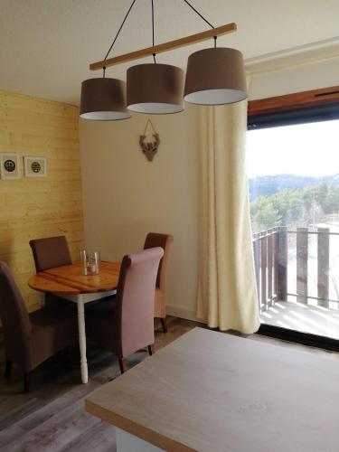 une salle à manger avec une table et une grande fenêtre dans l'établissement Appartement au pied des pistes, à Montclar