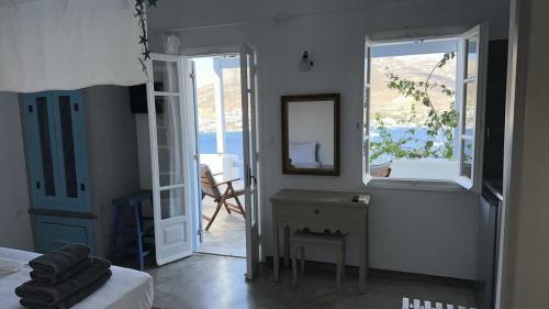 a bedroom with a bed and a mirror and a table at Amfitriti Serifos in Livadion