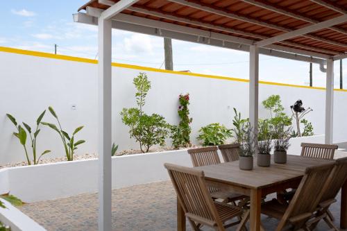 a patio with a wooden table and chairs at Casa La Rosa with private pool in Loja de Vendas