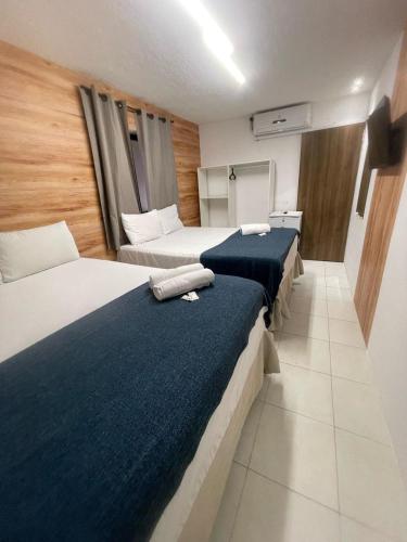 a hotel room with two beds with blue blankets at Pousada Maré Alta em Pajuçara in Maceió