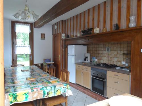 une cuisine avec une table et un comptoir dans l'établissement maison familiale ancien corps ferme baie de somme, à Feuquières-en-Vimeu