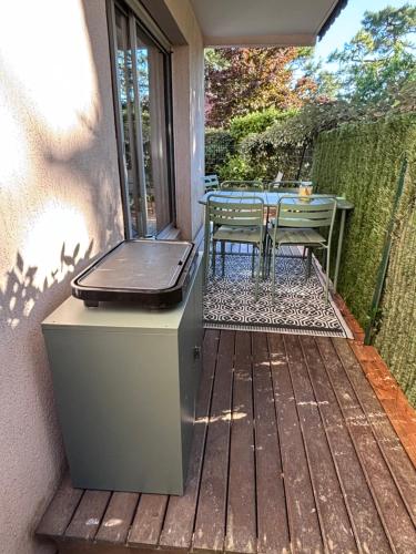 a patio with a grill and a table on a deck at Les terrasses de la Baule in La Baule