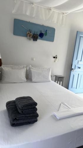 a white bed with a pile of towels on it at Amfitriti Serifos in Livadion