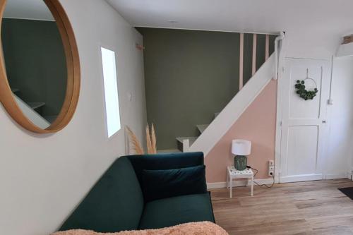 - un salon avec un canapé vert et un miroir dans l'établissement Cozy Home Near the Normandy Coast, à Douvres-la-Délivrande