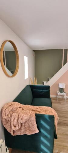 - un salon avec un canapé vert et un miroir dans l'établissement Cozy Home Near the Normandy Coast, à Douvres-la-Délivrande