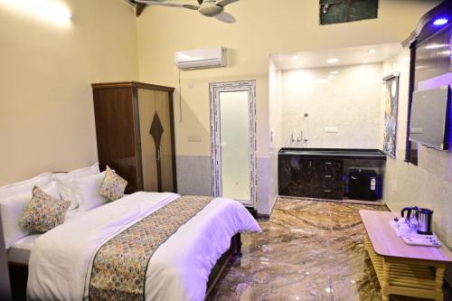 a hotel room with a bed and a bathroom at Popli Paradise Resort in Jaipur