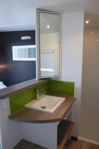 une salle de bain avec un lavabo et un miroir dans l'établissement Camping 3 étoiles - ccaa0ib, à Sainte-Reine-de-Bretagne
