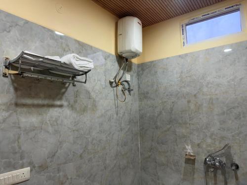 a bathroom with a shower with a glass door at Popli Paradise Resort in Jaipur