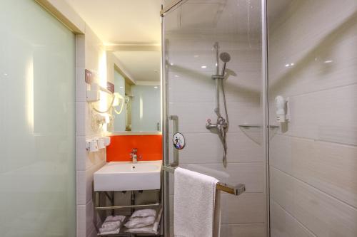 a bathroom with a white sink and a shower at 7Days Premium Guangzhou Tianhe Shipaiqiao in Guangzhou