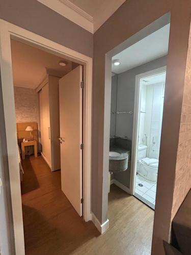 a bathroom with a sink and a toilet in a room at Hotel Aeroporto Congonhas com cozinha e sacada 1108 S in Sao Paulo