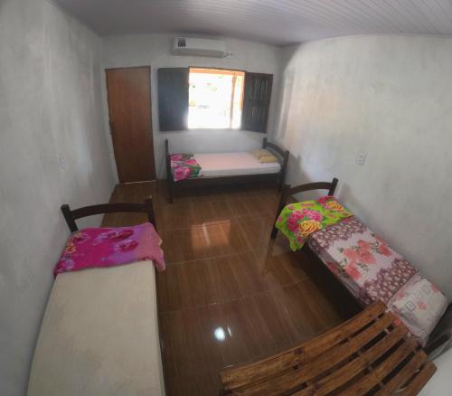 a small room with two beds and a window at Hostel Lençóis em Santo Amaro MA in Santo Amaro