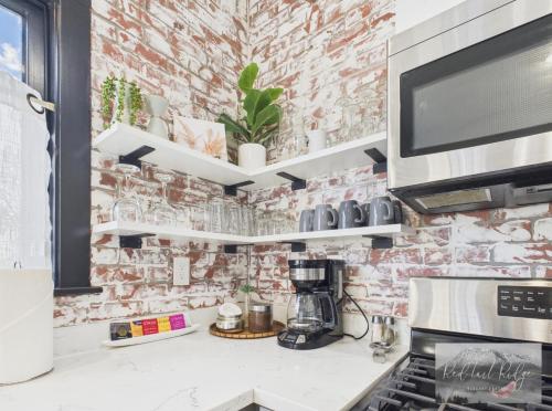 a kitchen with a brick wall at Boho Revival Modern Glam with AC in Downtown Albany in Albany