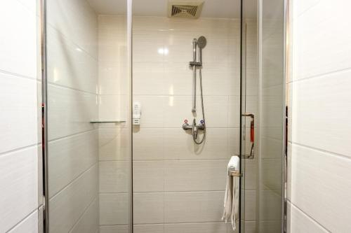 a shower with a glass door in a bathroom at 7Days Premium Guangzhou Tianhe Shipaiqiao in Guangzhou