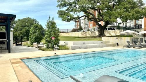 a large swimming pool with a tree in the background at 1BR Getaway Pool Gym in Austin