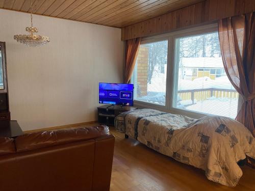 a bedroom with a bed and a tv and a window at Dream Big House Tervaharju in Kemi