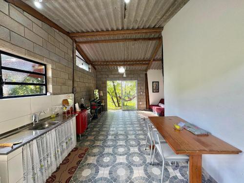 a kitchen with a table and a dining room at Casa Café - Aconchego na Floresta - Rota do Vinho in São Roque