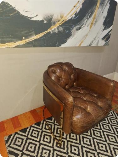 a brown leather chair in a room with a painting at Richmond Hill Guest House in Port Elizabeth