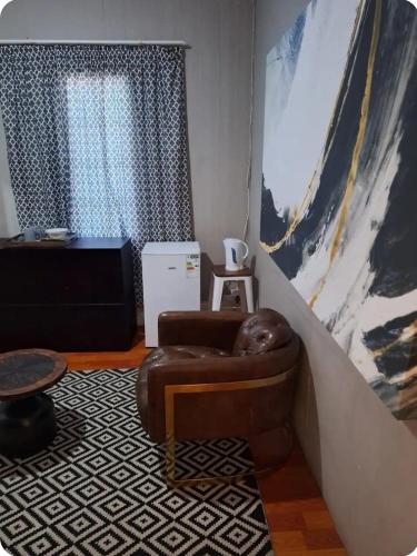 a living room with a chair and a large painting at Richmond Hill Guest House in Port Elizabeth