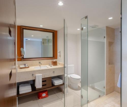 a bathroom with a shower and a sink and a toilet at Marival Emotions Resort & Suites Riviera Nayarit by Mercure in Nuevo Vallarta