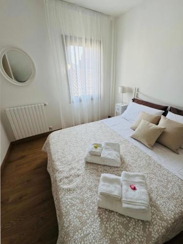 a white bedroom with two towels on a bed at Casa AnnaPaola in Chioggia