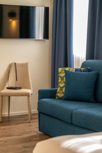 a blue couch and a chair in a living room at Hotel Rovereto in Rovereto