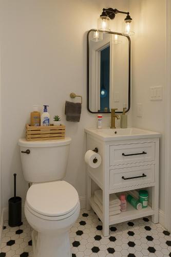 a bathroom with a white toilet and a mirror at Downtown Huntsville Gem in Muskoka in Huntsville